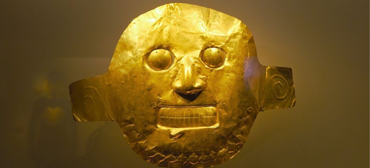 Máscara precolombina de orfebrería indígena en el Museo del Oro de Bogotá, símbolo del legado cultural de Colombia.