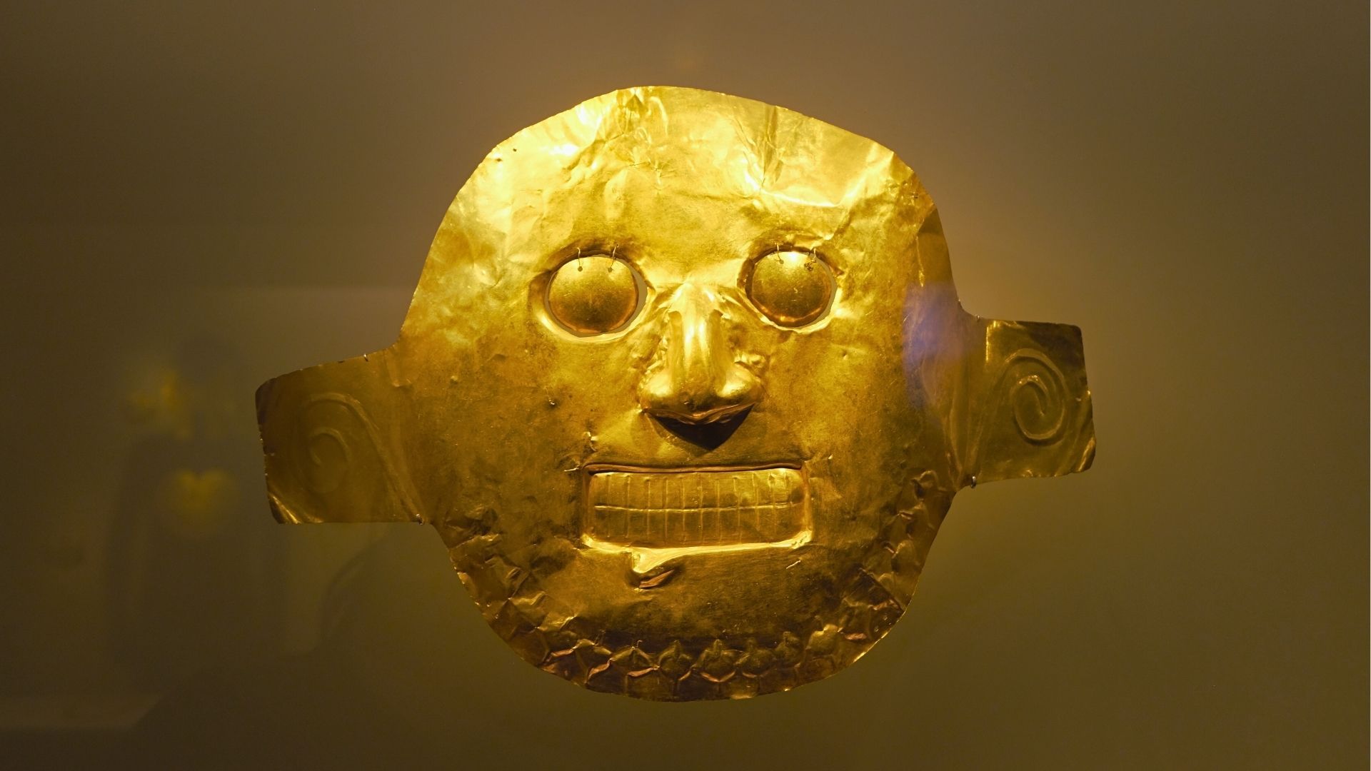 Máscara precolombina de orfebrería indígena en el Museo del Oro de Bogotá, símbolo del legado cultural de Colombia.