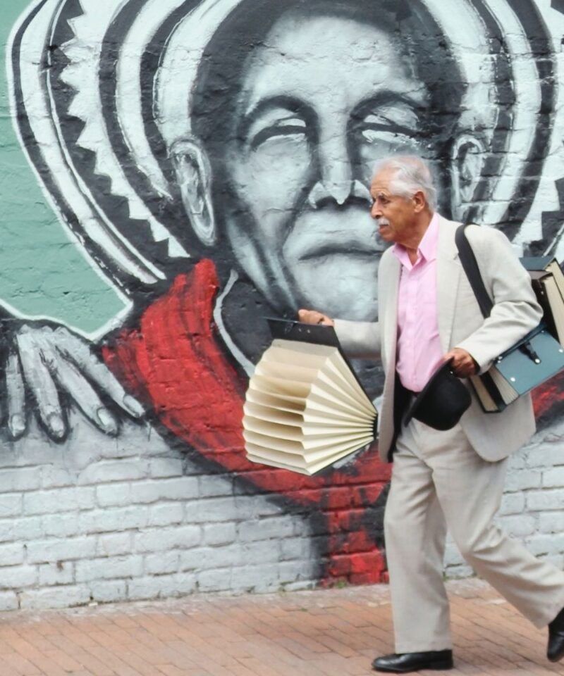 Vendedor ambulante cachaco en el centro histórico de Bogotá, símbolo de la elegancia tradicional y el espíritu trabajador de la capital colombiana – Colombia en Tour
