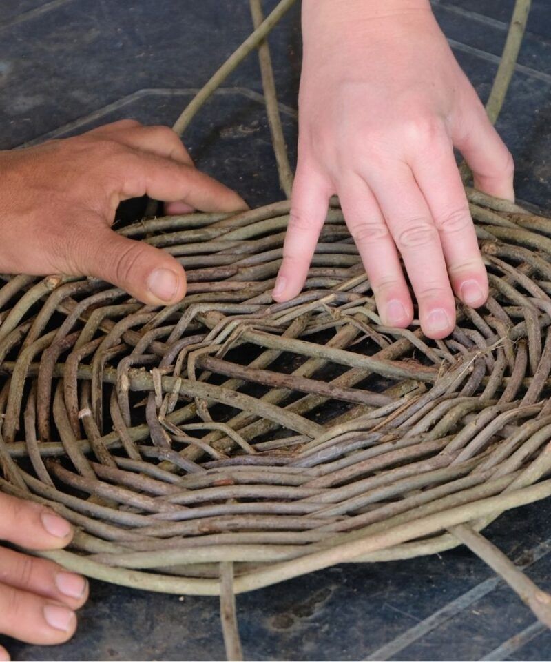 Manos tejiendo cestería artesanal en Barichara, experiencia de lujo tranquilo.