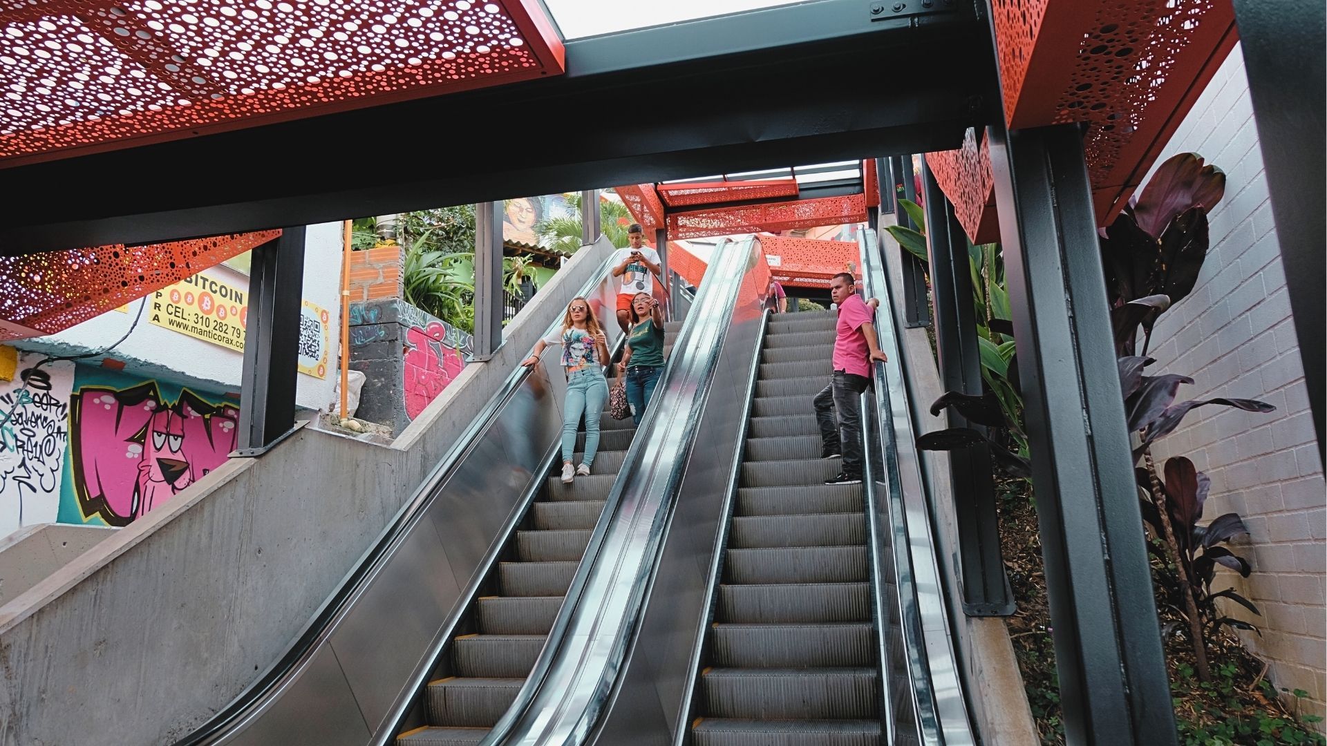 Escaleras eléctricas de la Comuna 13 en Medellín, rodeadas de murales de arte urbano