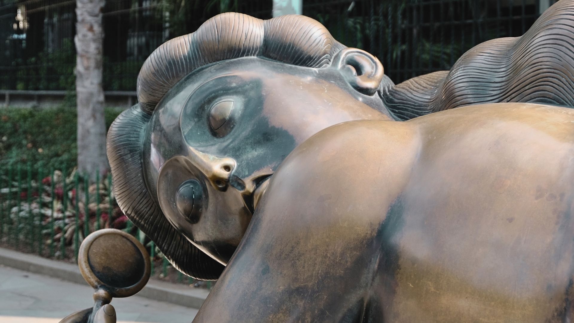 Tours de lujo en Medellín a medida – Viajes de diseño y transformación cultural para europeos. Escultura Mujer con espejo de Fernando Botero en Medellín, obra de bronce ubicada en el Parque Botero.