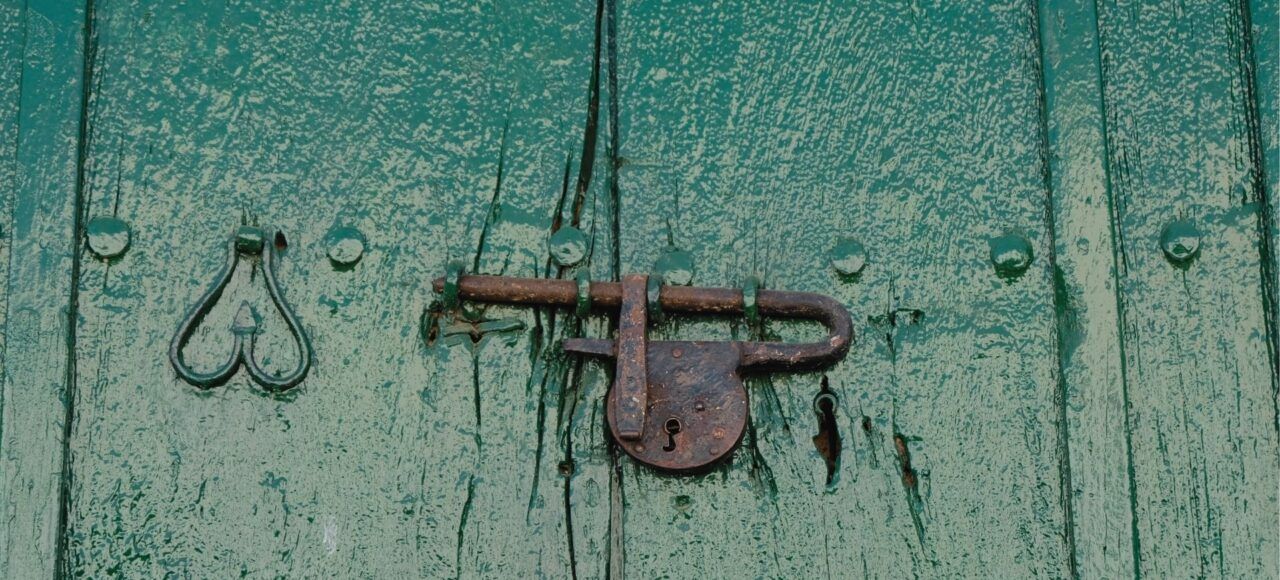 Detalle de puerta verde con candado hecho a mano en Mompox, artesanía colonial.