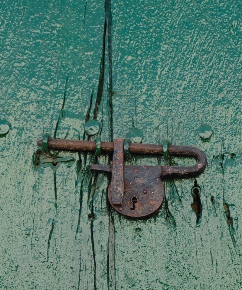 Detalle de puerta verde con candado hecho a mano en Mompox, artesanía colonial.