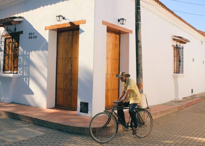 Hombre en bicicleta antigua por calles coloniales de Mompox, lujo artesanal e historia viva del Caribe colombiano.