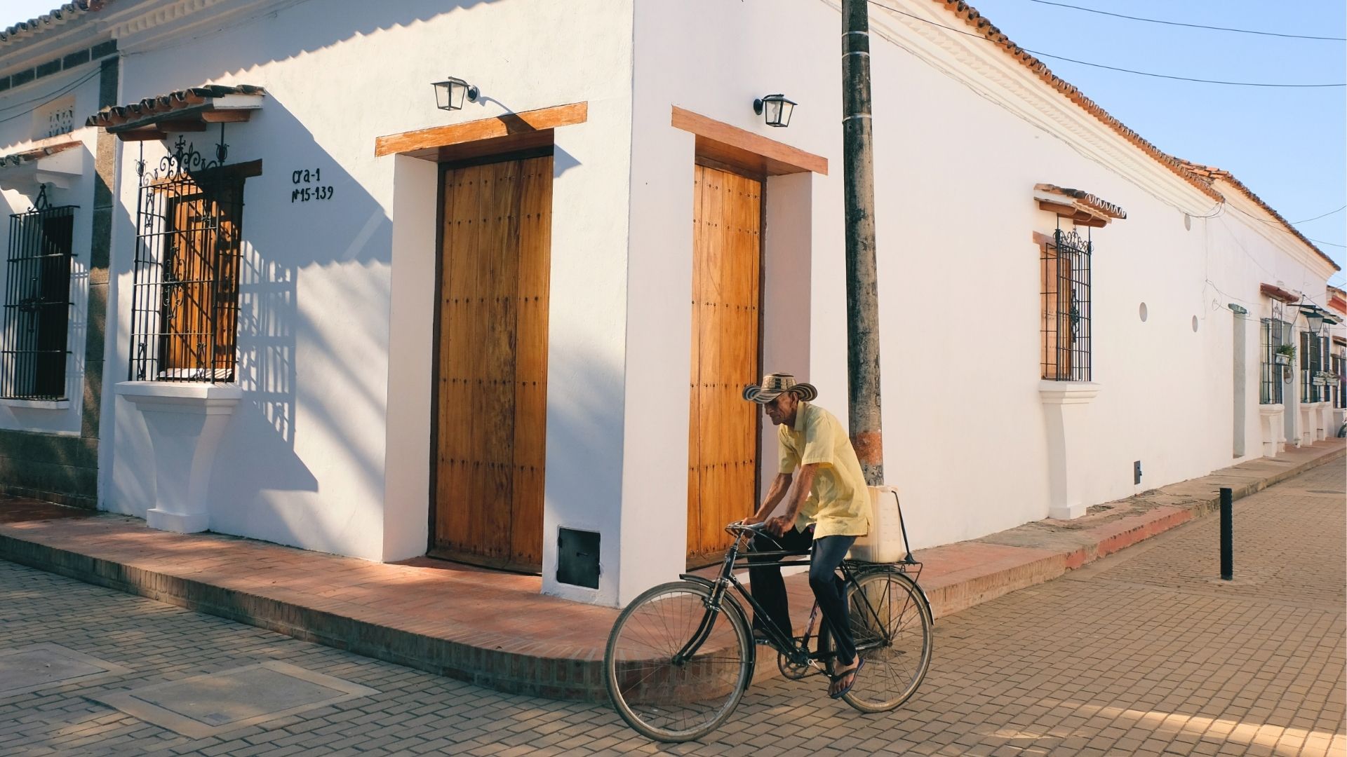 Hombre en bicicleta antigua por calles coloniales de Mompox, lujo artesanal e historia viva del Caribe colombiano.