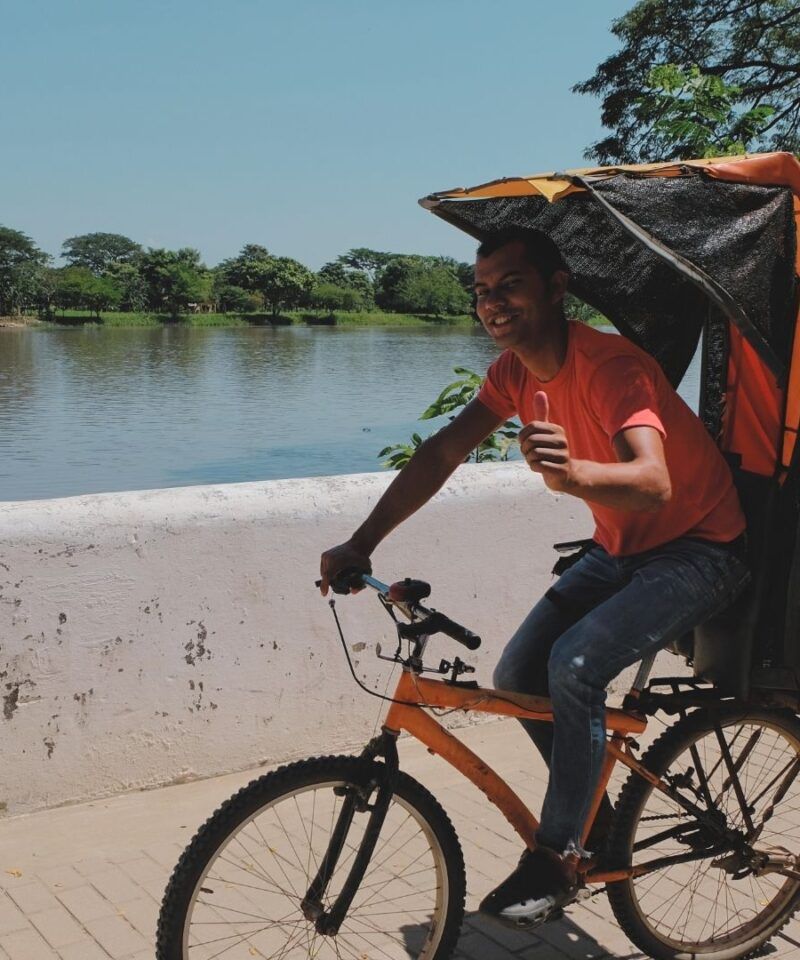 Habitante de Mompox sonriendo desde mototaxi tradicional, hospitalidad caribeña.