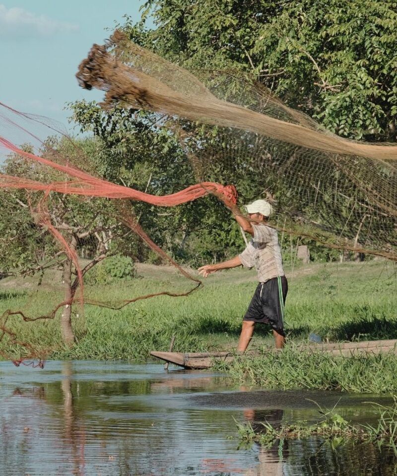Pescadores en faena en el Río Magdalena – Experiencias de lujo y vida ribereña auténtica en Colombia.