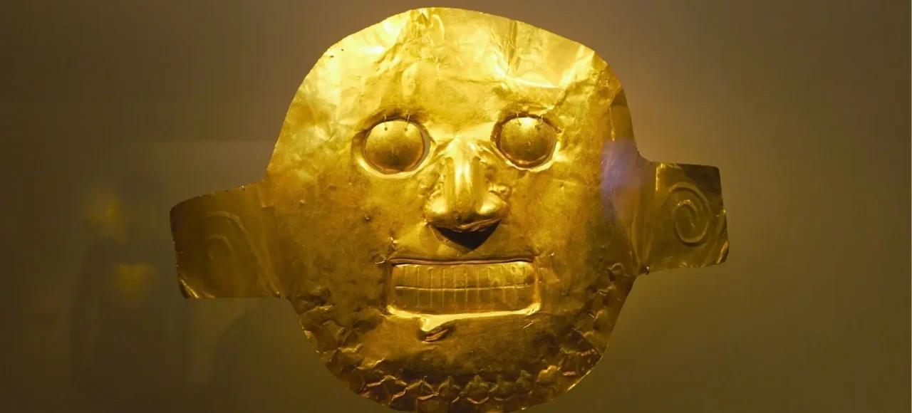 Máscara precolombina de orfebrería indígena en el Museo del Oro de Bogotá, símbolo del legado cultural de Colombia.